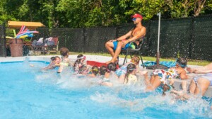 A group of campers and a lifeguard at a pool.