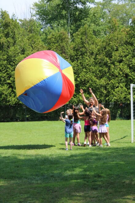 Campers playing with a mondoon beach ball