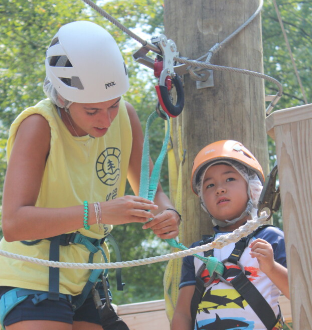 Staff and camper at adventure course